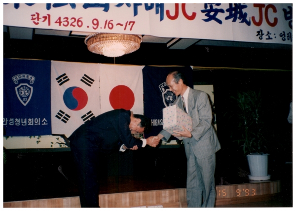 일본 자매JC 회원 환영식/ 1993. 9.16~17일 안성을 방문한 일본 동송산(東松山)JC 회장에게 환영식장에서 기념품을 전달하고 있는 필자(당시 안성JC 특우회장)의 모습이다